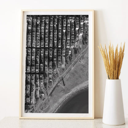 Aerial cityscape and black and white poster of Barceloneta beach and city grid aerial view, framed and displayed in modern living room decor