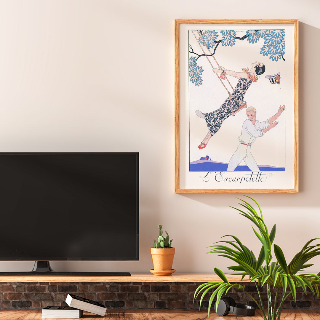 Art Deco poster of a woman on a swing with a man beneath under a tree from LEscarpotette by George Barbier, framed and displayed in home decor