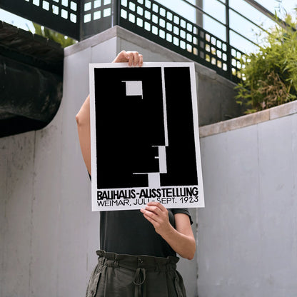 Black and white geometric abstract Bauhaus artwork by Joost Schmidt and László Moholy-Nagy featuring poster design with abstract shapes, framed and displayed in modern living room decor