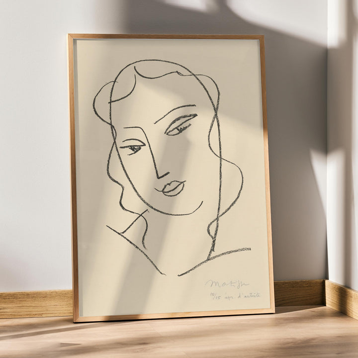 Henri Matisse Veiled Head poster with minimalist veiled face in black linework on a warm pale background, framed and displayed in modern living room decor