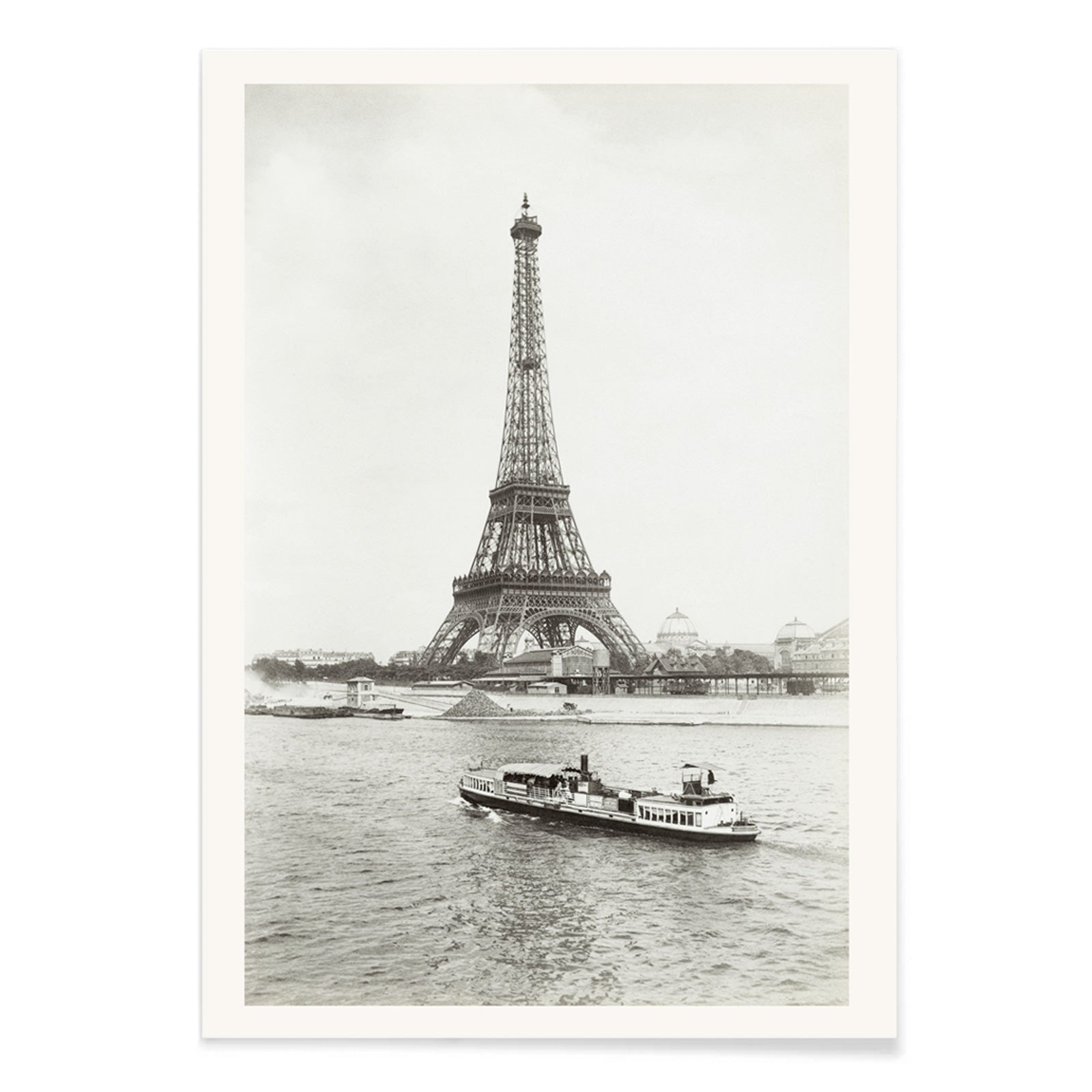 Black and white photograph and poster of the Eiffel Tower in Paris with a vintage boat on the Seine river wall decor artwork, with black aluminium frame on white background