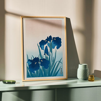 Poster of vibrant blue irises with green leaves on a gradient background artwork Blue Irises by Ohara Koson, framed and displayed in home decor