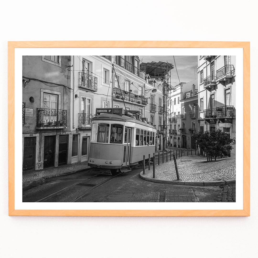 Lisbon Tramway 28 Black and White historic tram navigating cobblestone streets in Lisbon street scene poster, framed and displayed in modern living room decor