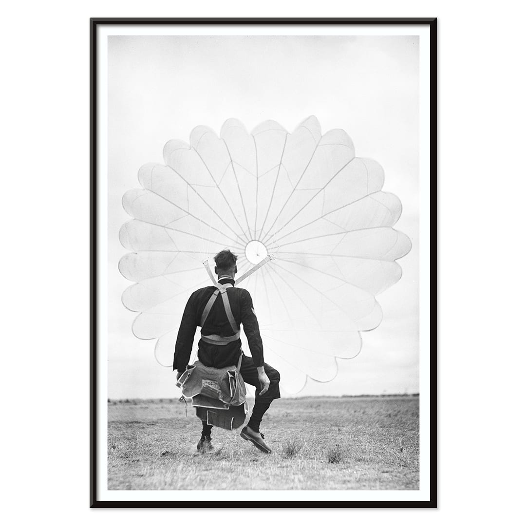 Air force parachuter landing and standing with deployed parachute by Ray Olsen poster, with black aluminium frame on white background