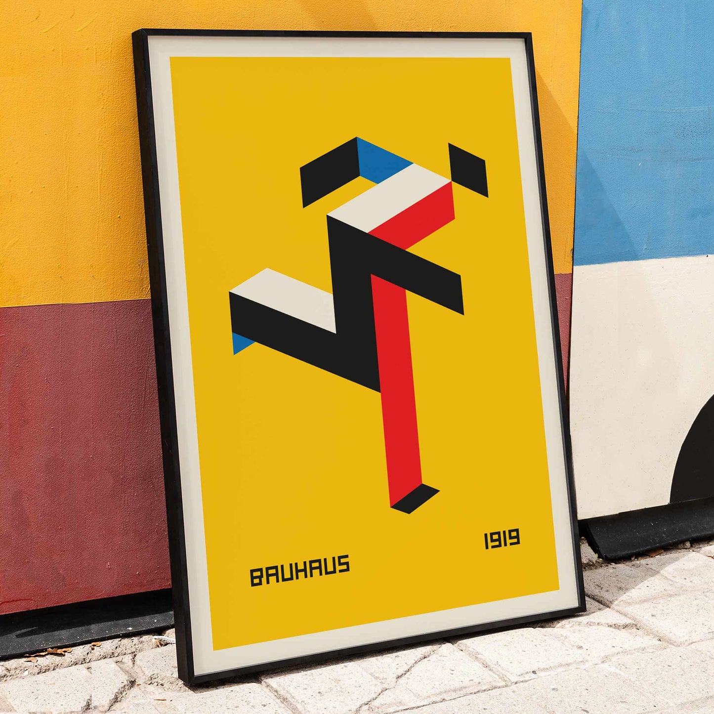 Geometric abstract art poster with red black white and blue shapes on yellow background by Bauhaus titled Bauhaus 20, framed and displayed in home decor
