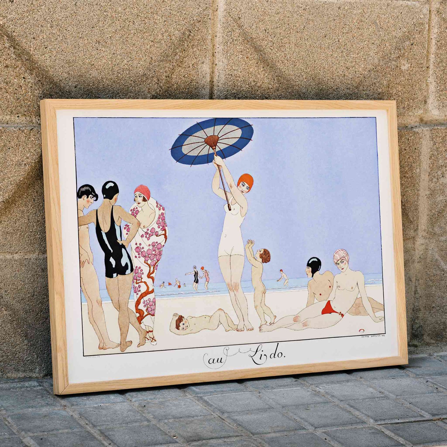 Art Deco beach scene with women children and people in swimsuits relaxing and playing on the beach Au Lido Plate by George Barbier, framed and displayed in home decor