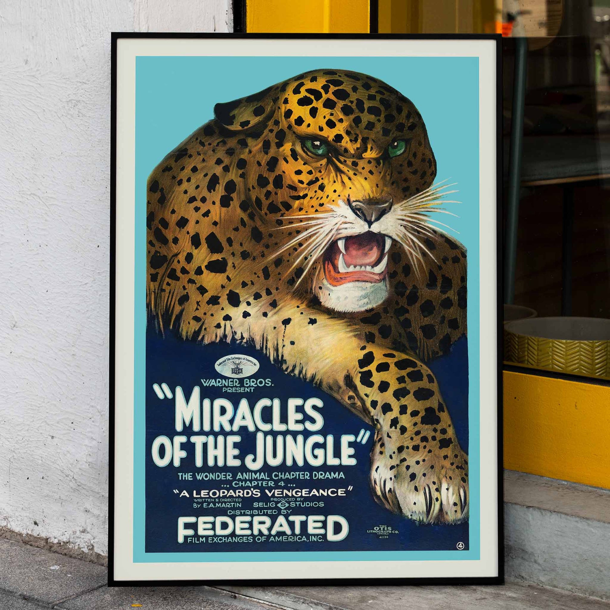 Miracles of the Jungle poster with a fierce roaring leopard by E A Martin Selig Studios featuring striking green eyes and bold text on a blue background, framed and displayed in home decor