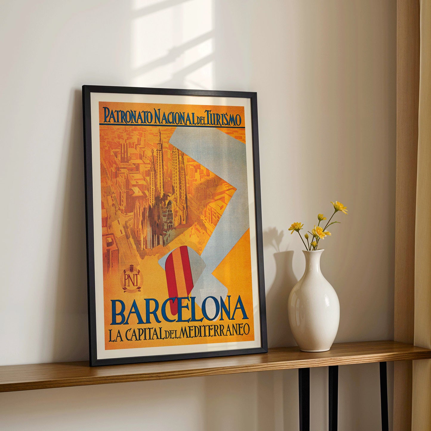 Barcelona La Capital del Mediterraneo poster by Patronato Nacional del Turismo featuring city skyline cathedral cityscape and flying flag, framed and displayed in home decor