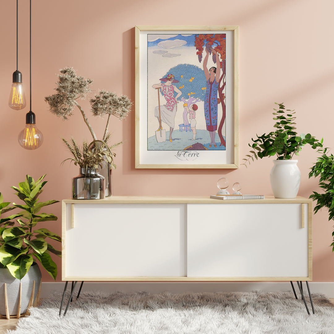 Art Deco illustration and poster by George Barbier featuring women and a child harvesting fruit in a colorful stylized garden, framed and displayed in home decor