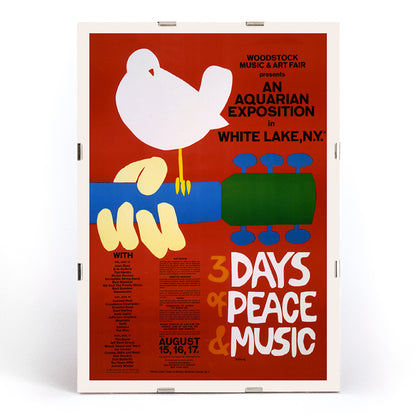 Woodstock poster with white dove on guitar promoting peace and music at An Aquarian Exposition in White Lake artist unknown, framed and displayed in modern living room decor